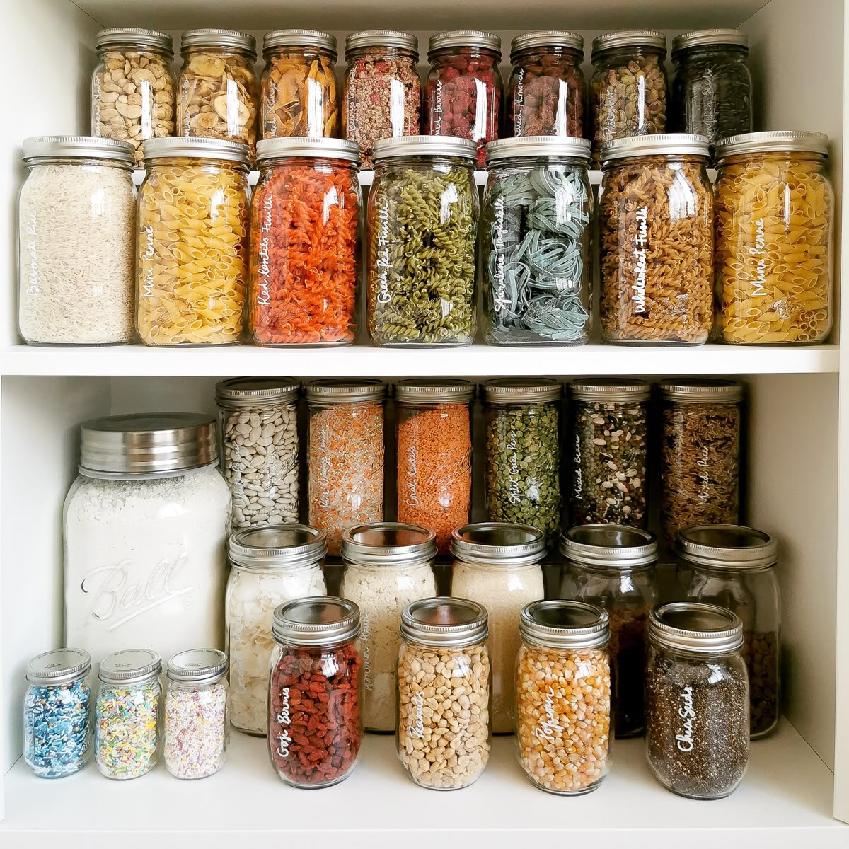 Neatly labelled pantry shelves with transparent storage containers and grouped food categories